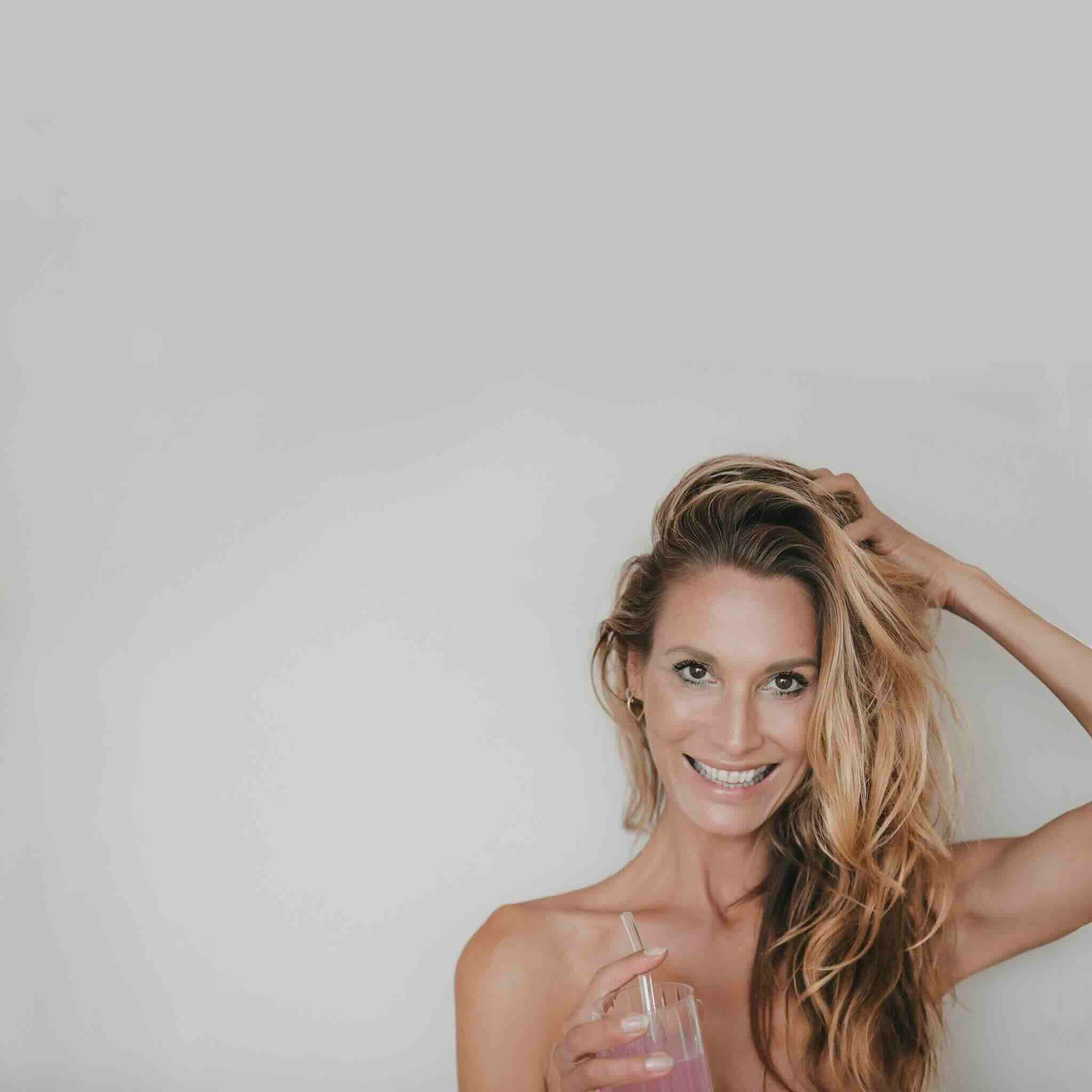 Strahlende Frau mit Collagen-Drink für gesundes Haar und Haut – Beautyhacker Lifestyle.
